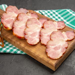 vista frontal de jamon fresco en rodajas en el escritorio de madera y color gris de la foto de la comida carne de cerdo crudo